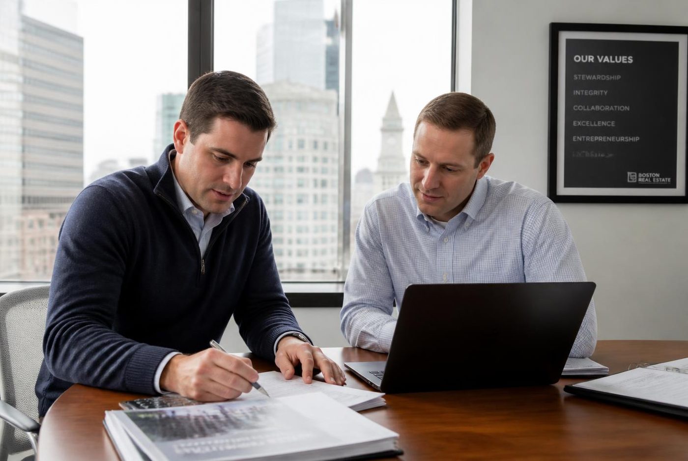 Two asset managers reviewing a property portfolio in a Boston office